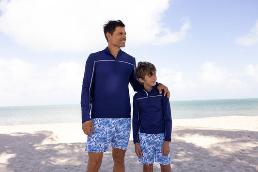 Father and son on beach wearing Men's Charleston Paisley Swim Trunks with Men's Navy Sport Zip Top and Boys Navy Sport Zip Top with Boys Charleston Paisley Swim Trunks