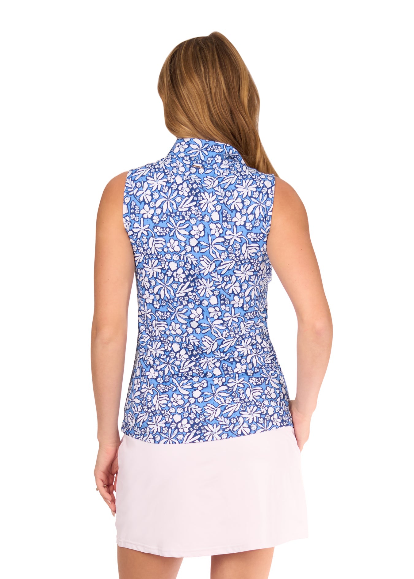 The back of a blonde woman wearing the sun protective and navy floral Seaside 1/4 Zip Sleeveless Sport Top and White Skort from Cabana Life on a white background.