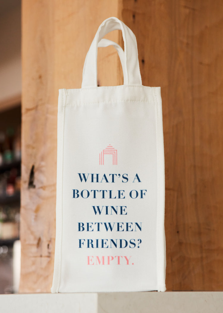 A Cabana Life wine bag on a bar that says "What's a bottle of wine between friends? Empty."