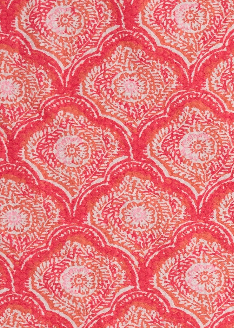 A close up of Cabana Life's Amelia Island pink and coral colored tile print with a watercolor stripe border on a UPF 50+ pique fabric.