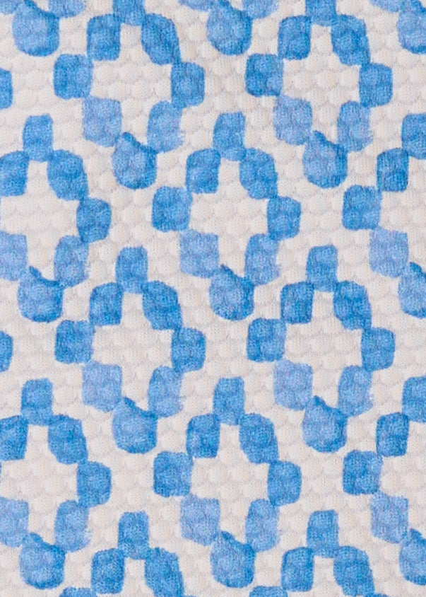 A close up of Cabana Life's Seaside light blue and white watercolor diamond print on a UPF 50+ pique fabric. 