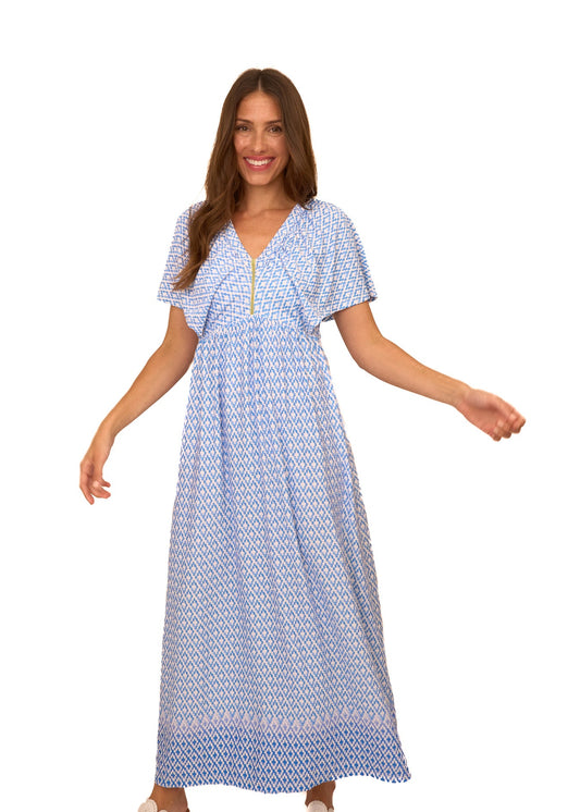 A brunette woman wearing the flowy Cabana Life sun protective Seaside Flutter Sleeve Maxi Dress on a white background.