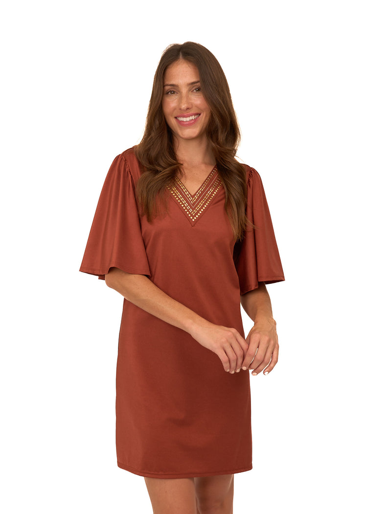 A brunette woman wearing Cabana Life's sun protective Copper Flutter Sleeve Shift Dress with her arms in front of her on a white background.