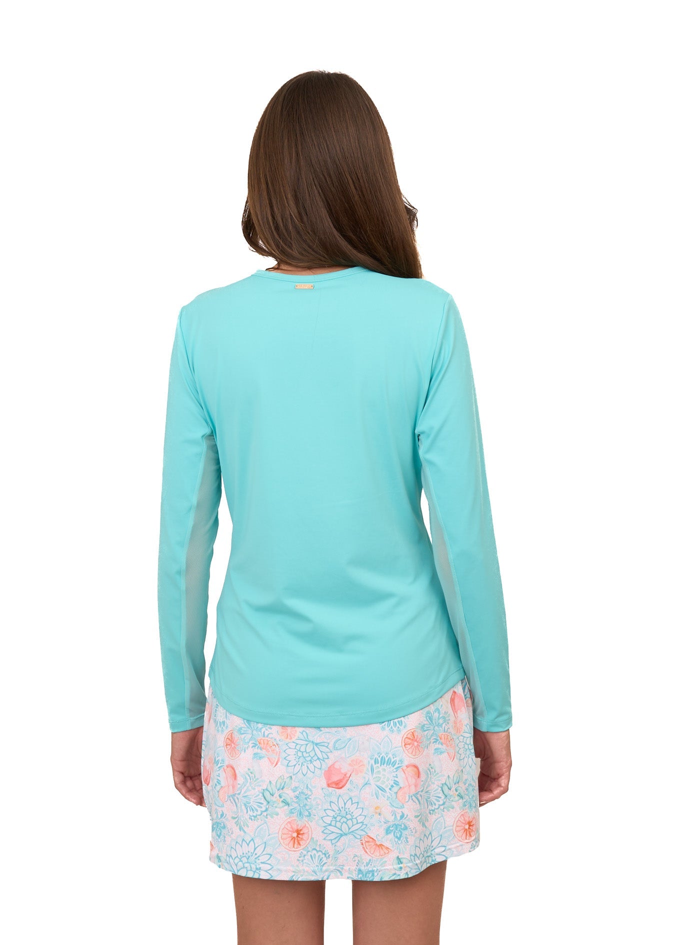 The back of a brunette woman wearing the sun protective Aqua Performance Crewneck and Spritz 15" Skort from Cabana Life on a white background.