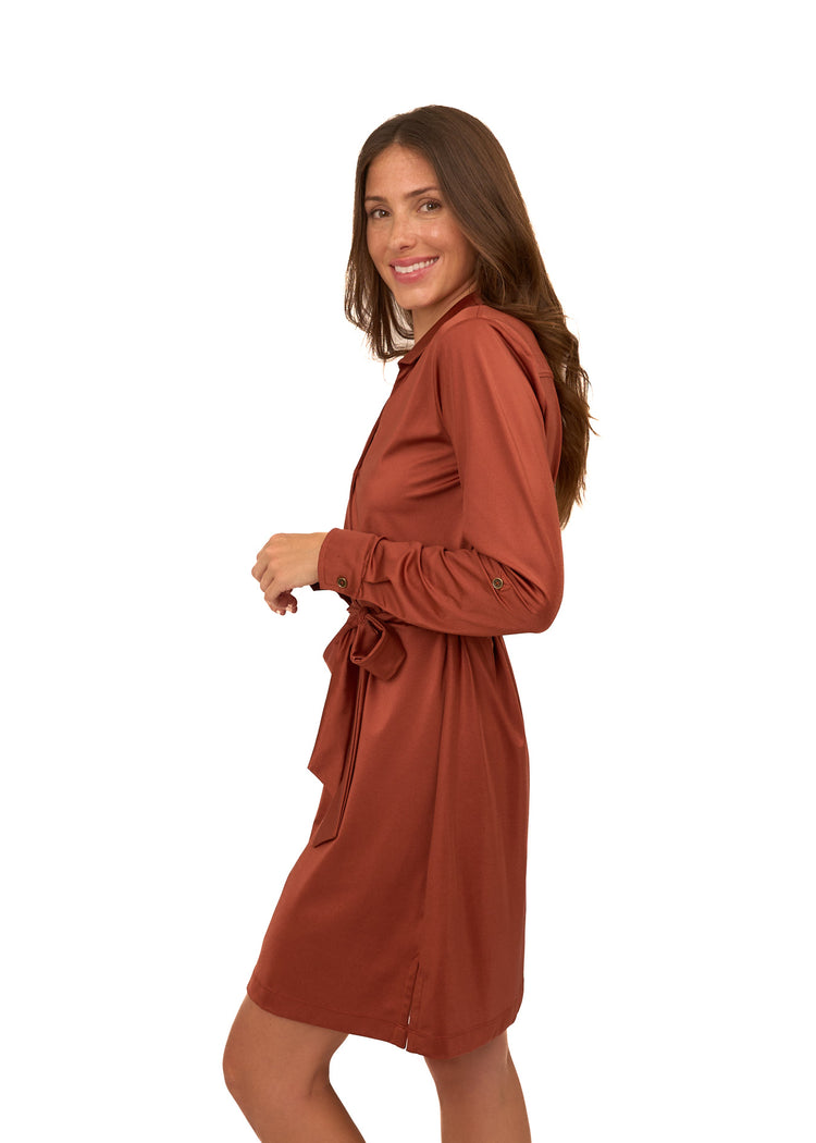 The side of a brunette woman wearing Cabana Life's sun protective Copper Button Down Shirt Dress on a white background.