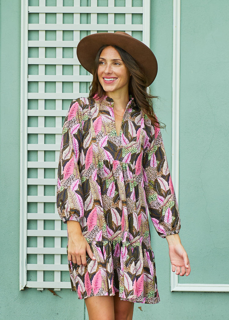 A brunette woman in front of a green building wearing a brown wide brim felt hat and Cabana Life's sun protective Myers Relaxed Dress.