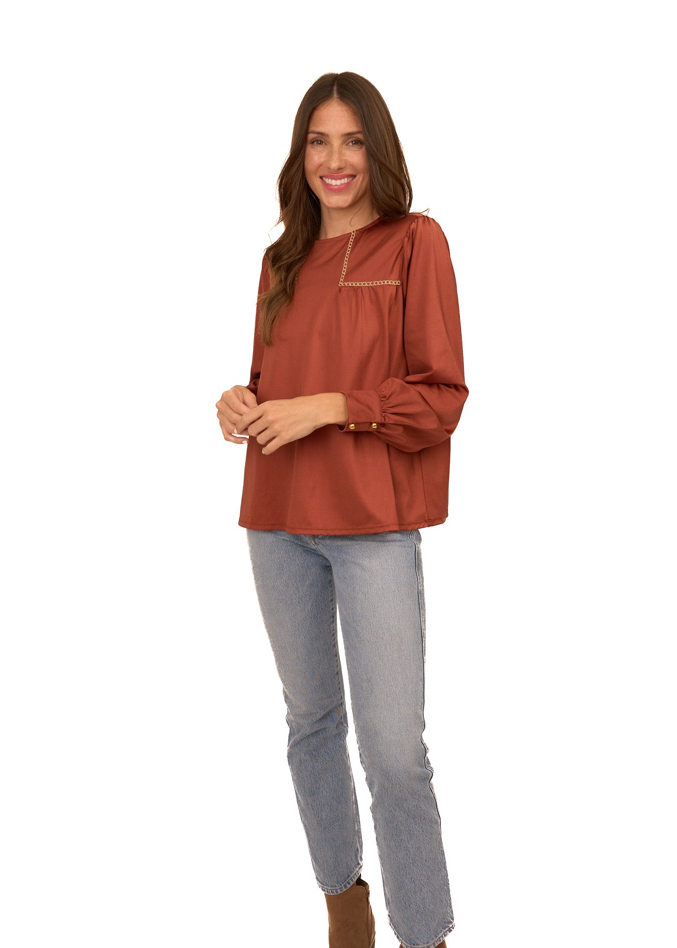 A brunette woman wearing Cabana Life's sun protective Copper Long Sleeve Top with light wash jeans on a white background.