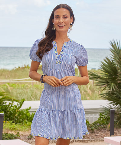 A brunette woman wearing the Cabana Life sun protective Navy Stripe Embroidered Tiered Dress.