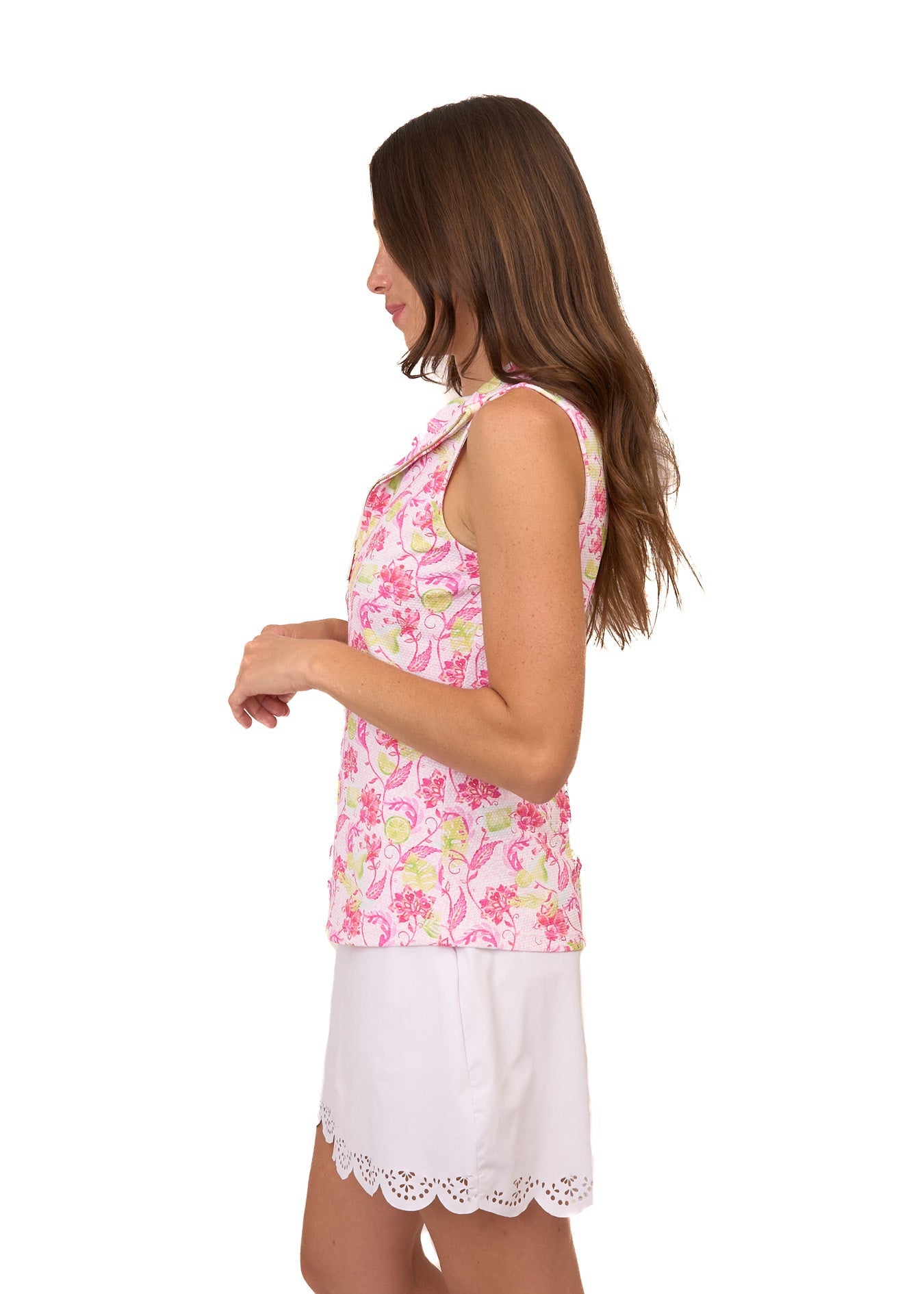 The side of a brunette woman wearing the sun protective Margarita Pique 1/4 Zip Sleeveless Sport Top and White 15" Scallop Skort from Cabana Life on a white background.