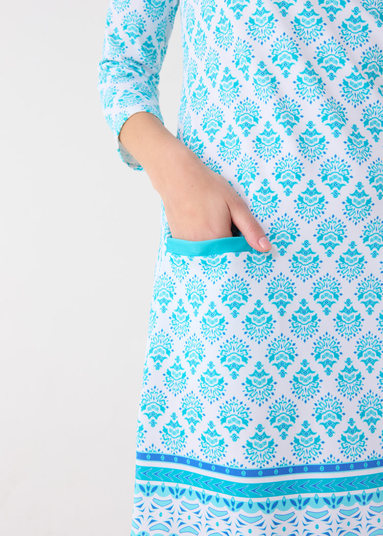 A woman's hand in the snap pocket of the Cabana Life sun safe Amalfi Coast Cabana Shift Dress.