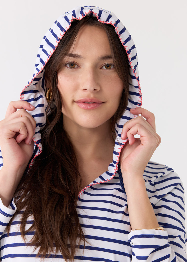 A brunette woman wearing the hood up on the Cabana Life sun protective Navy Stripe Hooded Cover Up.