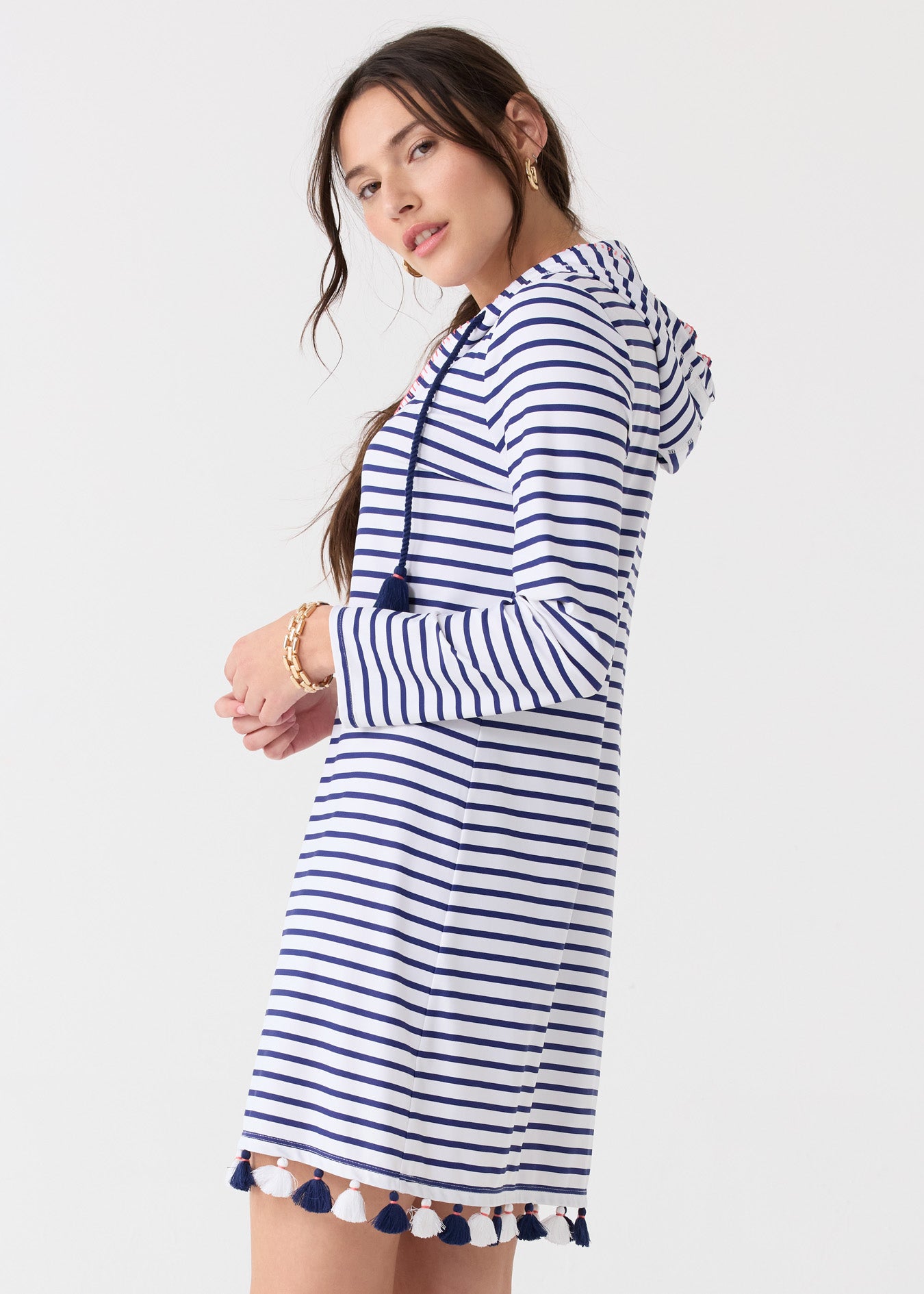 The side of a brunette woman wearing the Cabana Life sun protective Navy Stripe Hooded Cover Up.