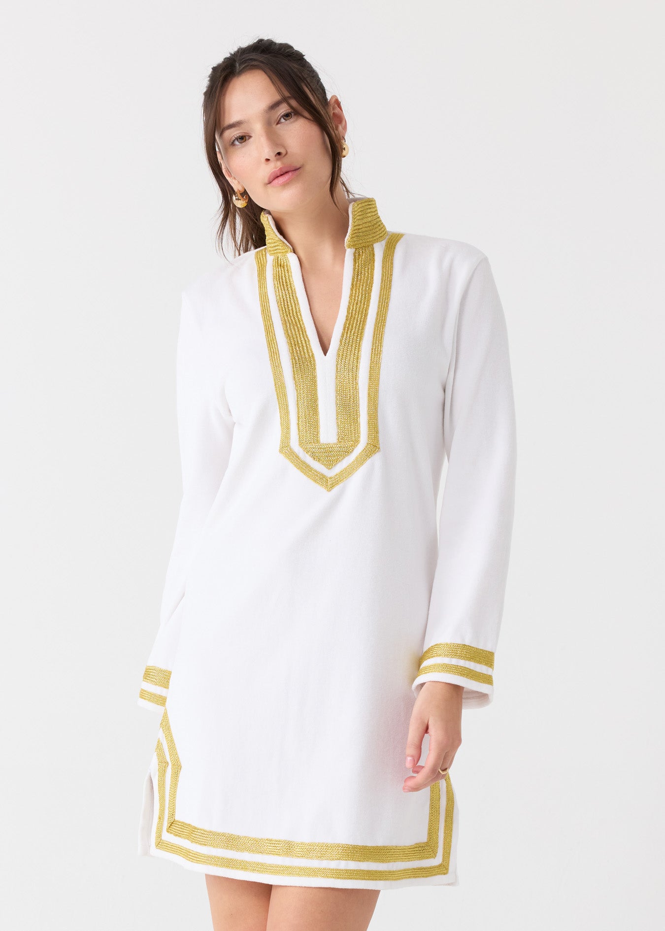 A woman with her dark hair up wearing the sun protective Cabana Life White/Gold Terry Tunic with gold hoop earrings.