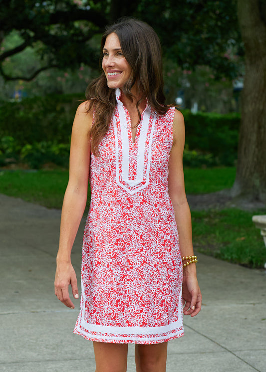 A brunette woman in a park wearing Cabana Life's sun protective Fiery Red Sleeveless Tunic Dress.