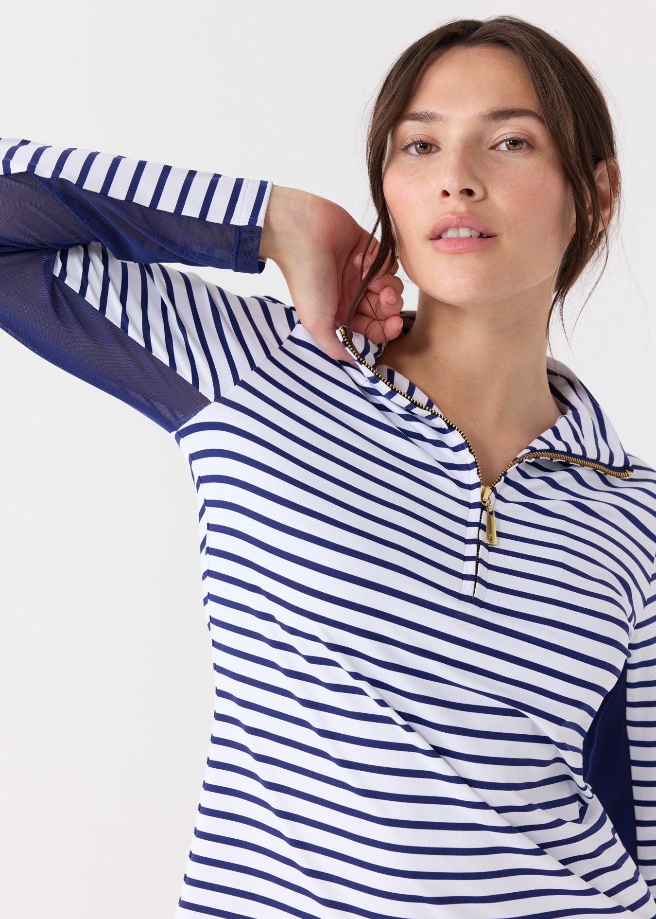 A woman wearing the Cabana Life sun protective Navy Stripe 1/4 Zip Sport Top with mesh underarm venting.