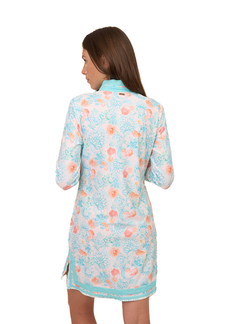 The back of a brunette woman wearing Cabana Life's sun protective Spritz Tunic Dress on a white background.