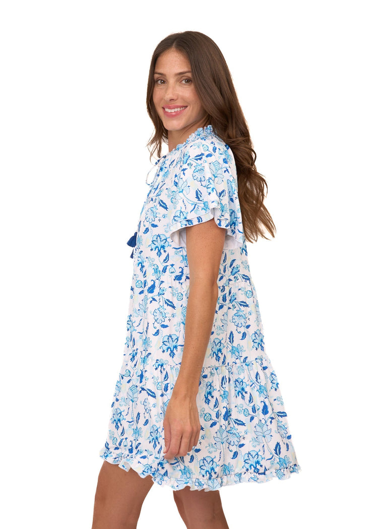 The side of a brunette woman wearing the sun protective Bubbly Short Sleeve Tiered Ruffle Dress from Cabana Life on a white background.