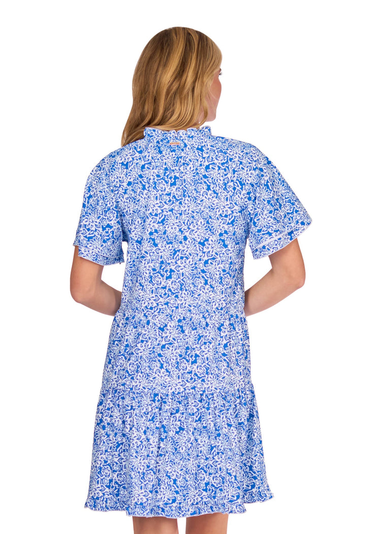 The back of a blonde woman wearing the sun protective Blue Short Sleeve Tiered Dress from Cabana Life on a white background.