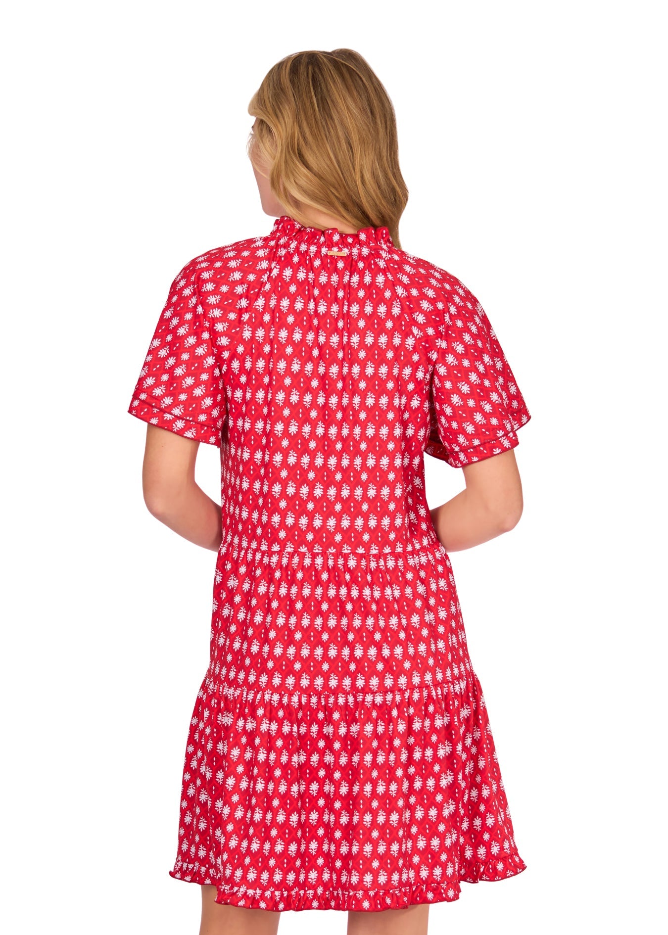 The back of a blonde woman wearing the sun protective Crimson Short Sleeve Tiered Dress from Cabana Life on a white background.