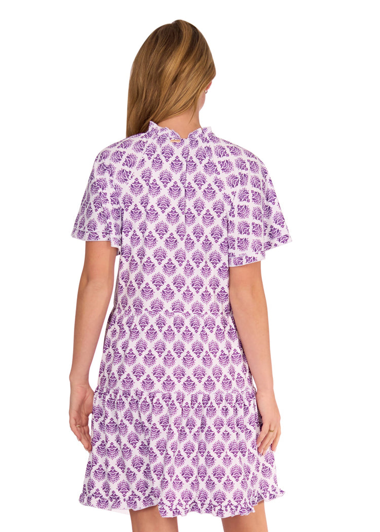 The back of a blonde woman wearing the sun protective Purple Short Sleeve Tiered Dress from Cabana Life on a white background.