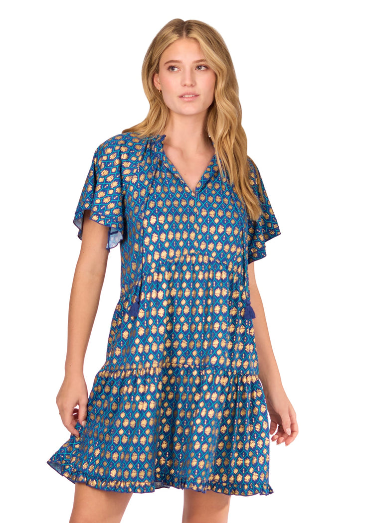 A blonde woman wearing the sun protective Navy Metallic Short Sleeve Tiered Dress from Cabana Life on a white background.