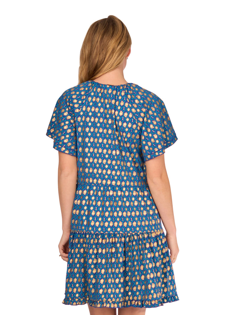 The back of a blonde woman wearing the sun protective Navy Metallic Short Sleeve Tiered Dress from Cabana Life on a white background.