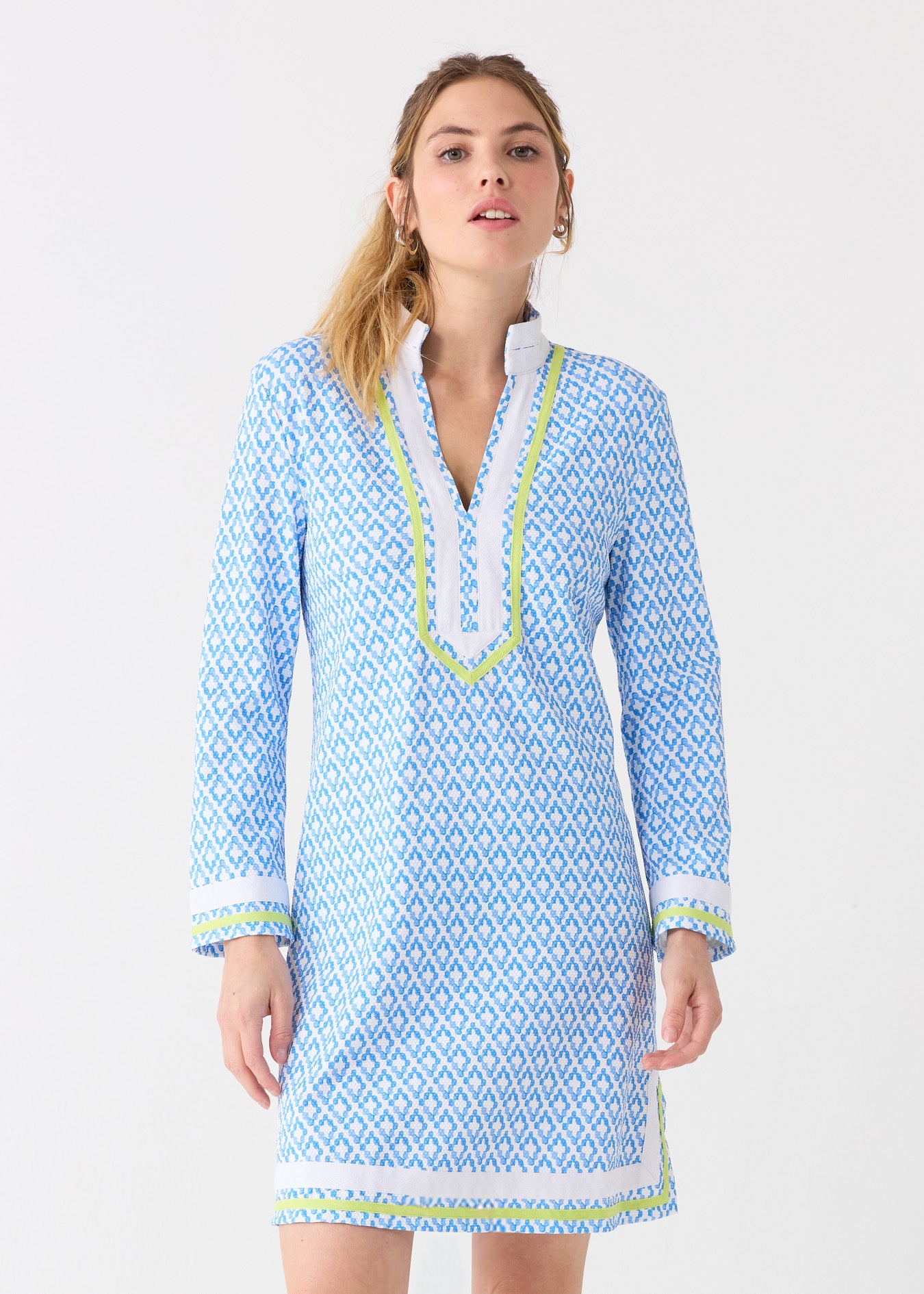 A blonde woman wearing the Cabana Life sun protective Seaside Pique Tunic Dress with gold hoops.