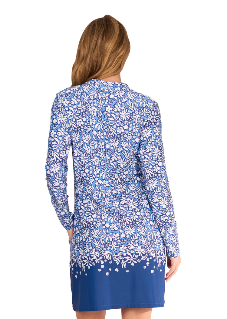 The back of a blonde woman wearing the sun protective & navy floral patterned Seaside 1/4 Zip Sport Dress from Cabana Life on a white background.