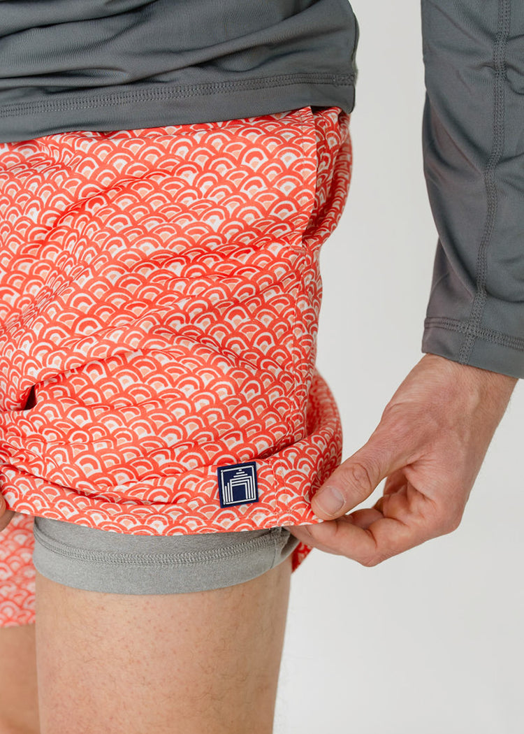 A man showing the grey comfort liner inside the sun protective Men's Amelia Island Swim Trunk from Cabana Life.