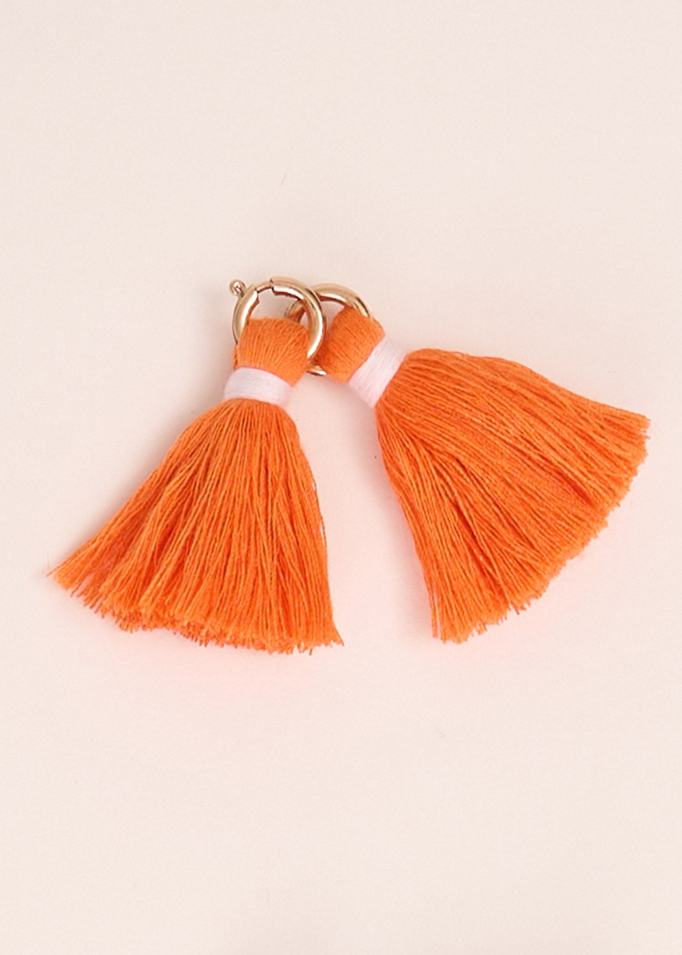 Cabana Life's Orange Game Day Tassel Set on top of each other on a white background.