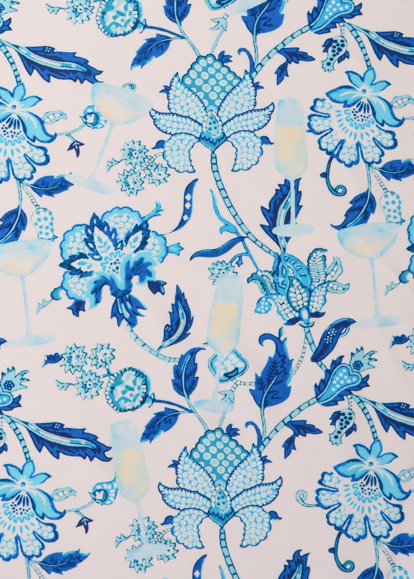 A close-up of Cabana Life's sun protective Bubbly print fabric featuring a blue floral print with champagne and white wine glasses.